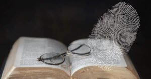 Glasses sitting on top of a Bible, with a large fingerprint in the foreground